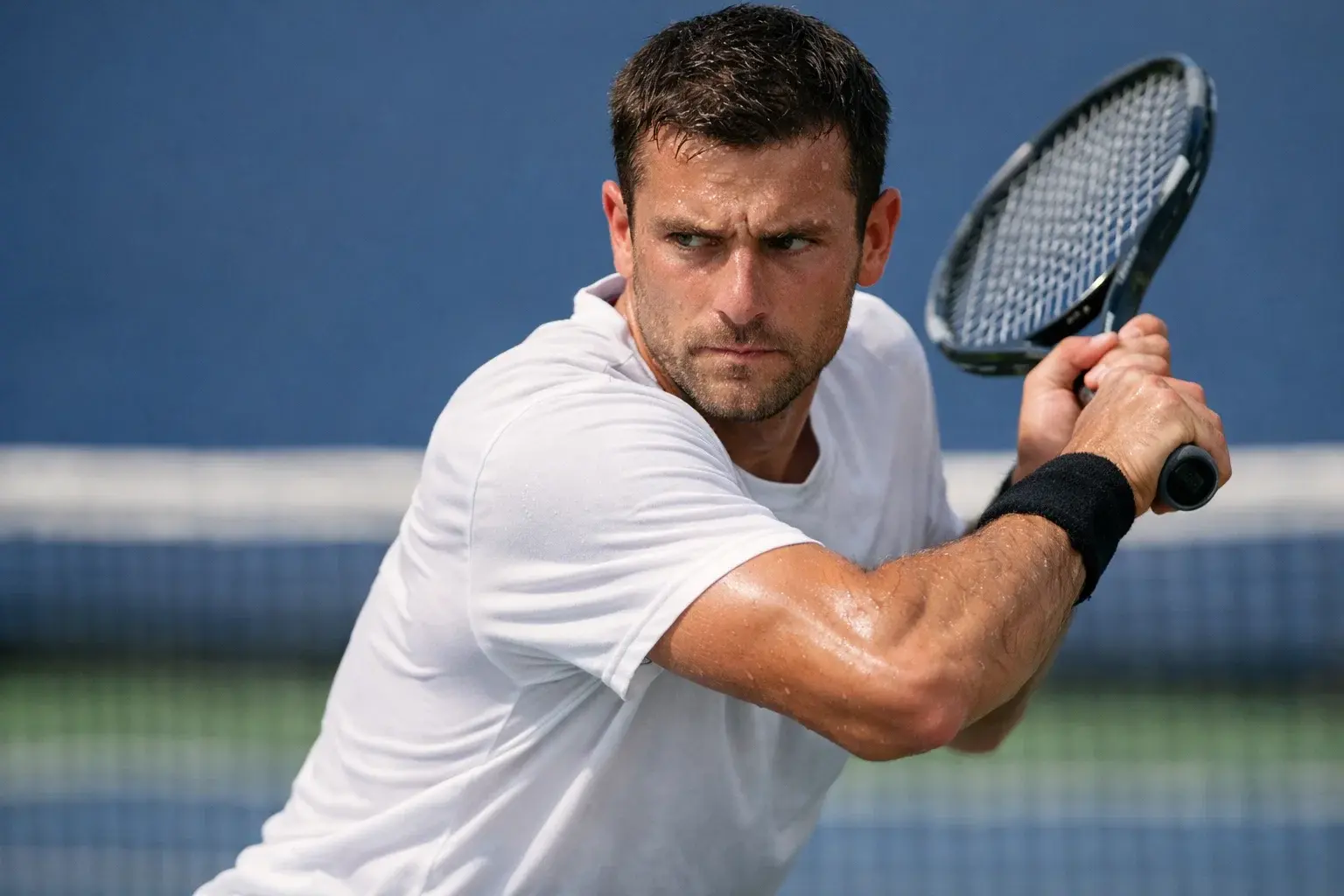 Joueur de tennis concentr&eacute; pendant un &eacute;change intense, raquette en main sur court dur