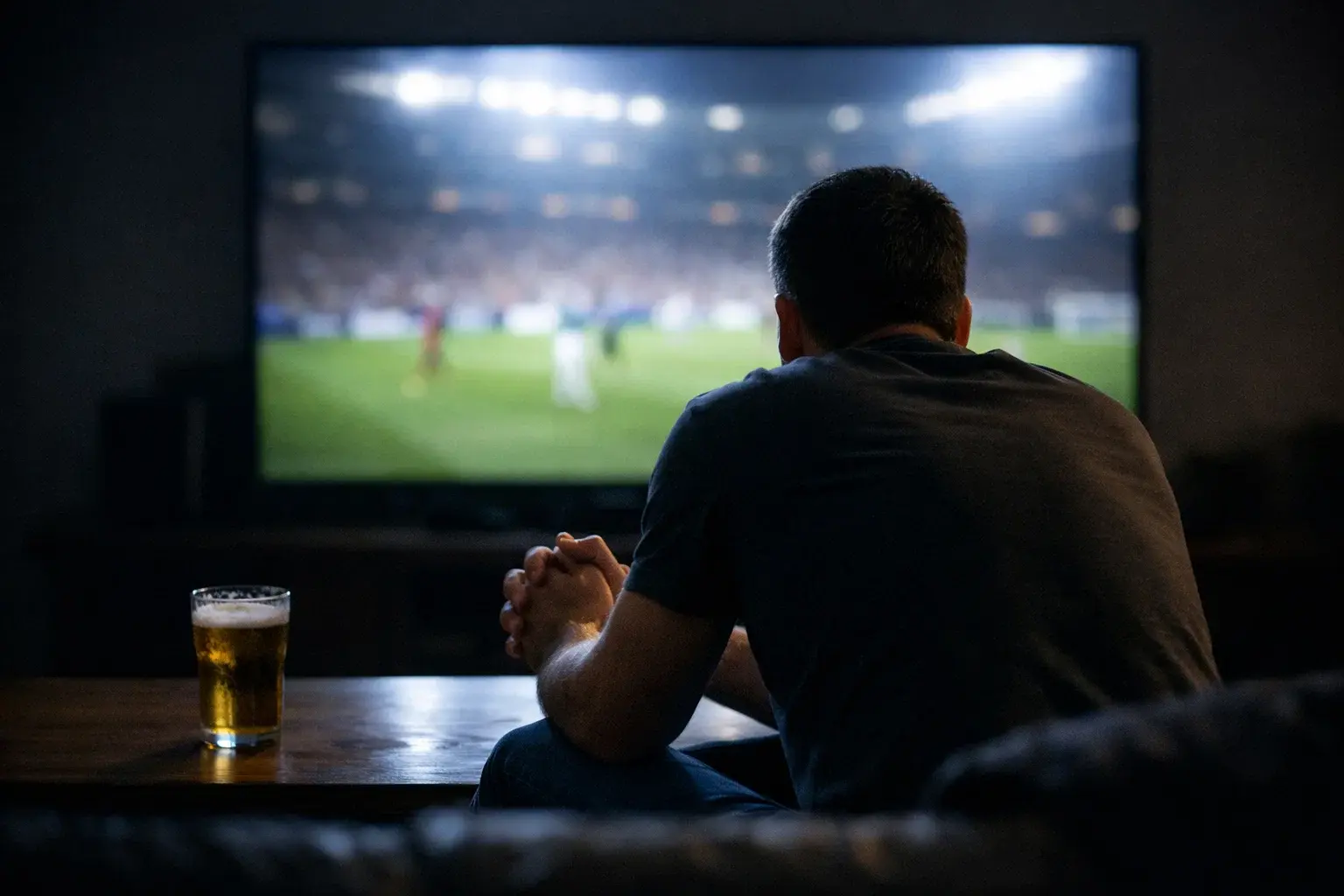 Personne regardant un match de sport avec tension et concentration